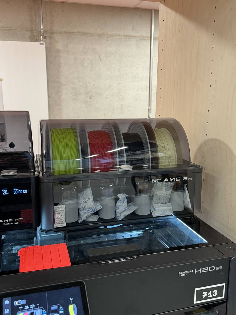 Oben auf dem Drucker: AMS 2 Pro (4 Rollen) und links daneben das AMS HT